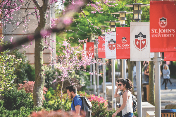 Image of St. John's University banners and two students walking into building