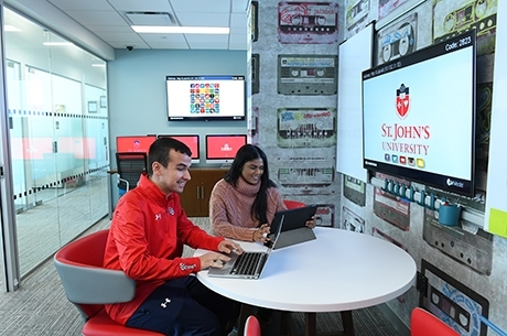 Male and female student on laptops in Homeland Security Lab