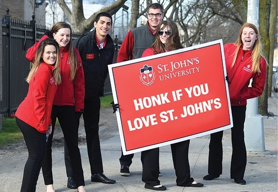 Six students holding a "Honk if you Love St. John's" sign