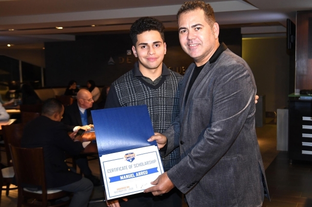 Male student holding certificate