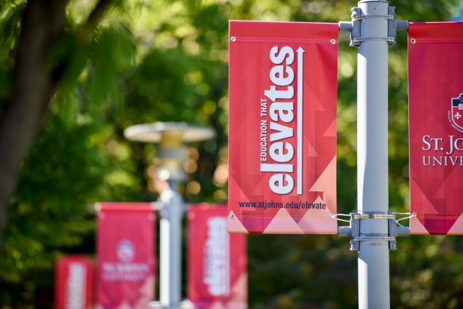 St. John's University Red Flags with the Words "Education that Elevates"