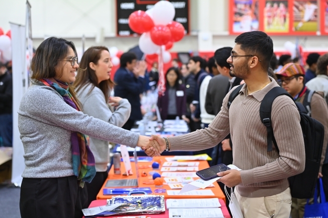 Student networking with career professional at a career fair