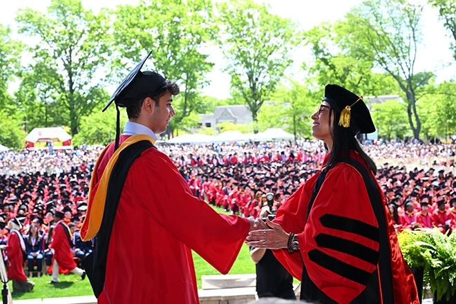 Grad student shaking Dean Delgado's hand onstage