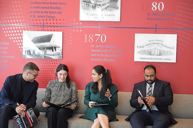 Grad students seated on a bench talking to each other