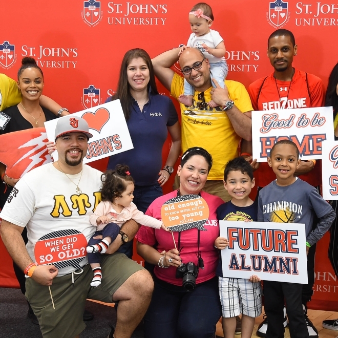 Family shot infront of St. John's University step and repeat sign