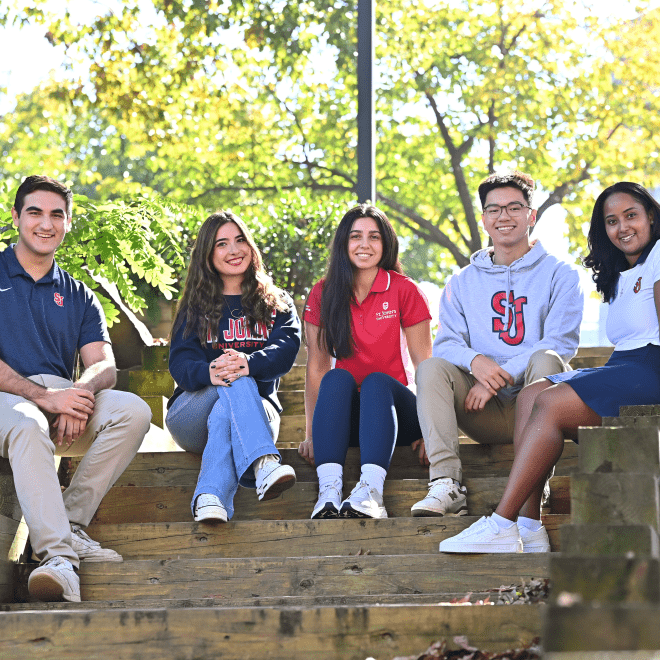 Group of St. John's University students sitting outside 