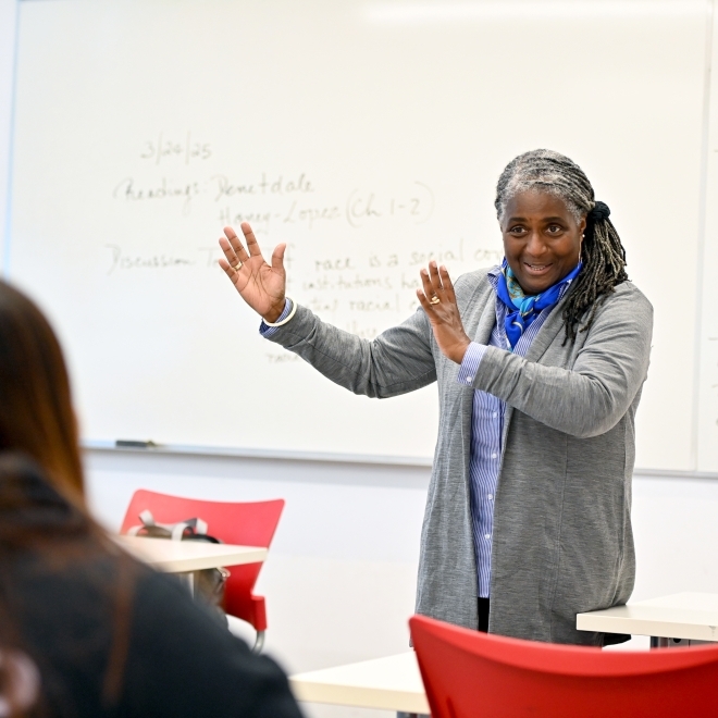 Female professor speaking to students in a classroom setting