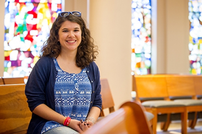 female student sitting in St. Thomas More Church