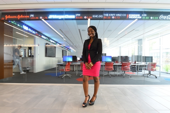 Graduate Student Standing in front of Tobin Stock Ticker