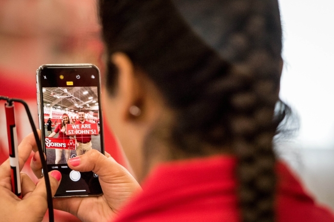 Female student taking photo of other students with her cell phone