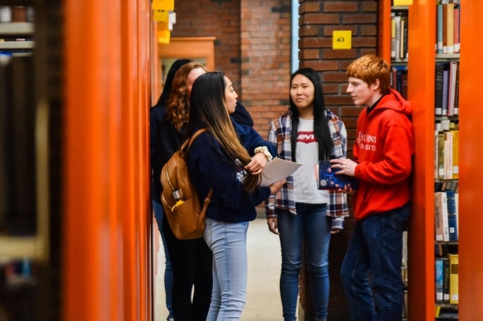 students talking to each other in library