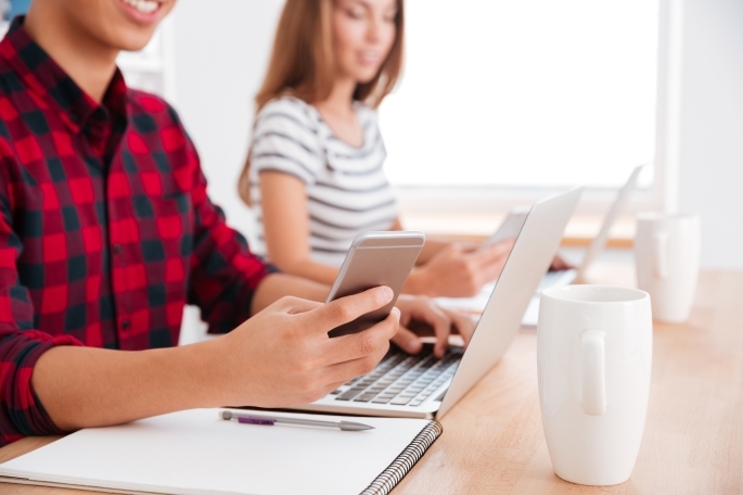 Students using mobile phones and laptops