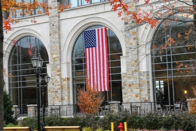American flag hanging from building on campus