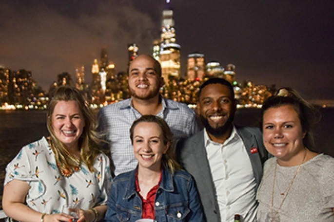 GOLD group on sunset cruise against NYC skyline