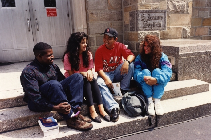 Students sitting on the steps of St. John Hall