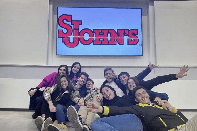 Friends of Fulbright Argentina pose for a group picture in front of projector image of "St. John's"