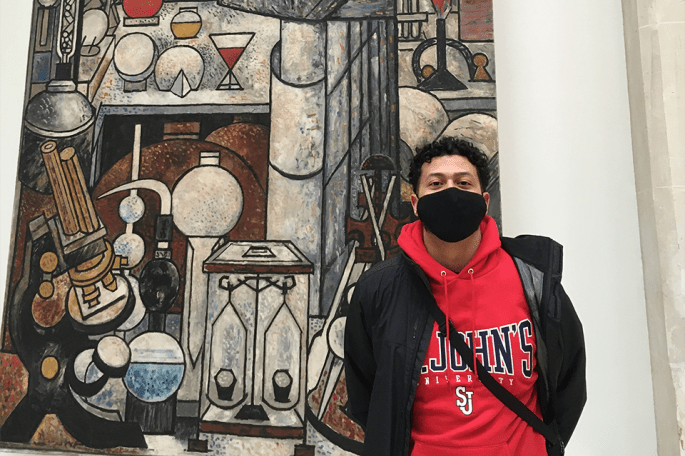 Manuel Martis in front of mural by Marcel Gromaire entitled “The Chemist”