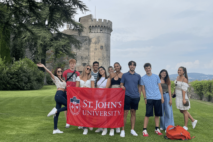 Johnnies in Rome pose for a photo with St. John's banner
