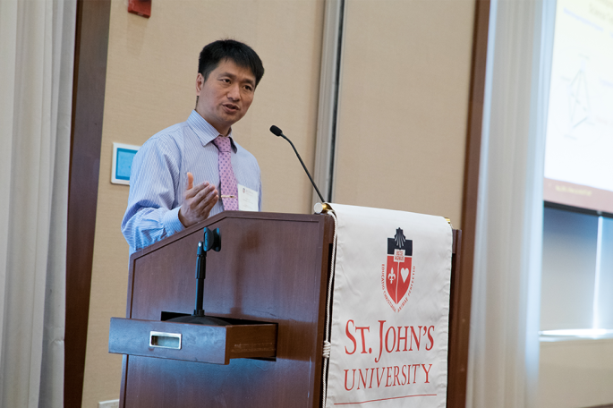 Speaker standing at podium at Jarowoski Symposium