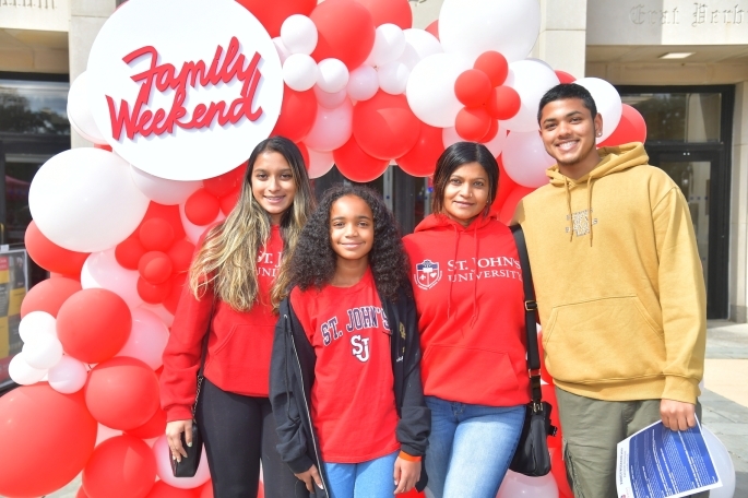 Family in front of Family Weekend sign at St. Johns