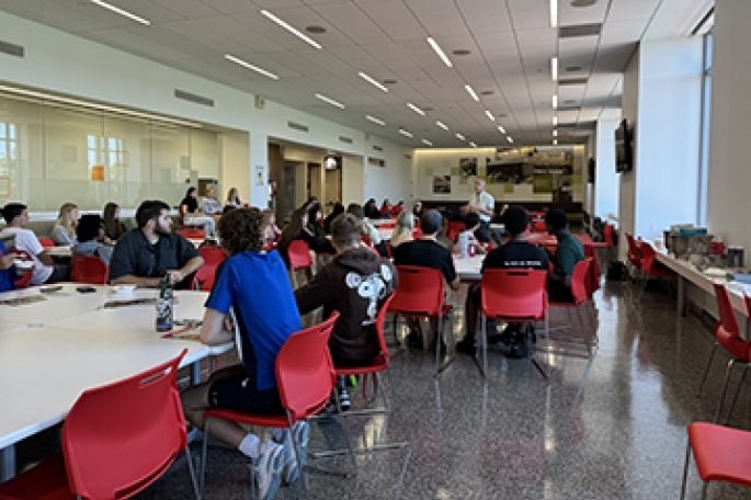 Students sitting down inside dining area