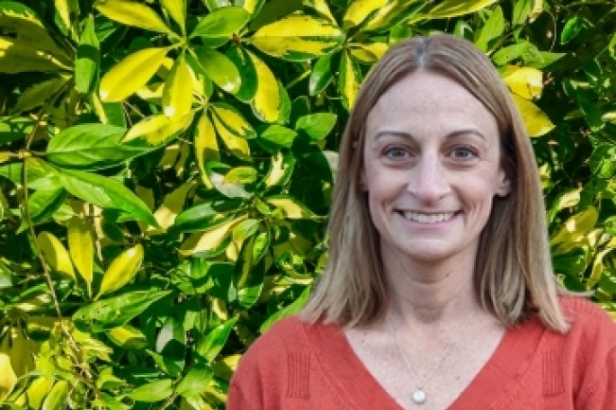 Kelly DelGaizo, Ed.D. headshot infront of foliage