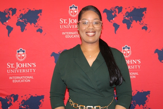 Alyssa Palmer in front of SJU global step and repeat banner