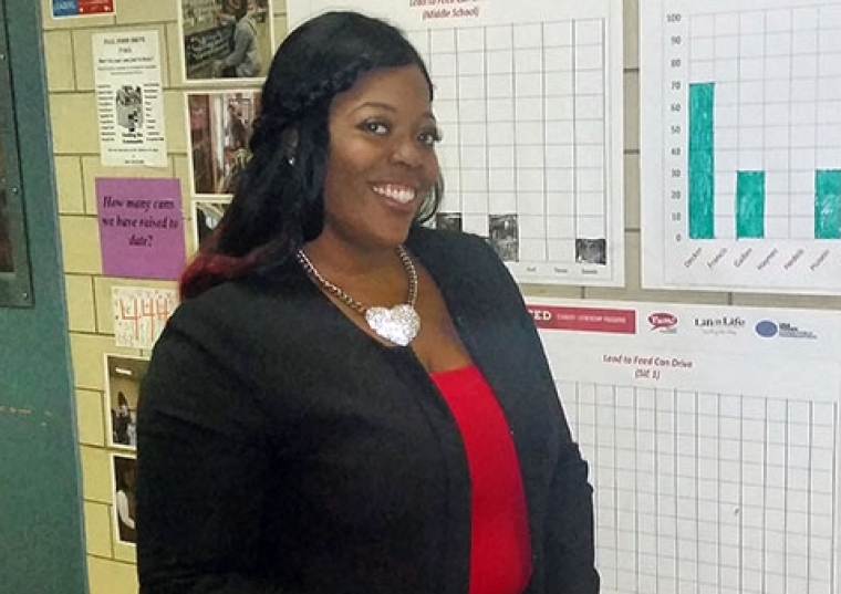 Latasha Jones stands in front of graphs