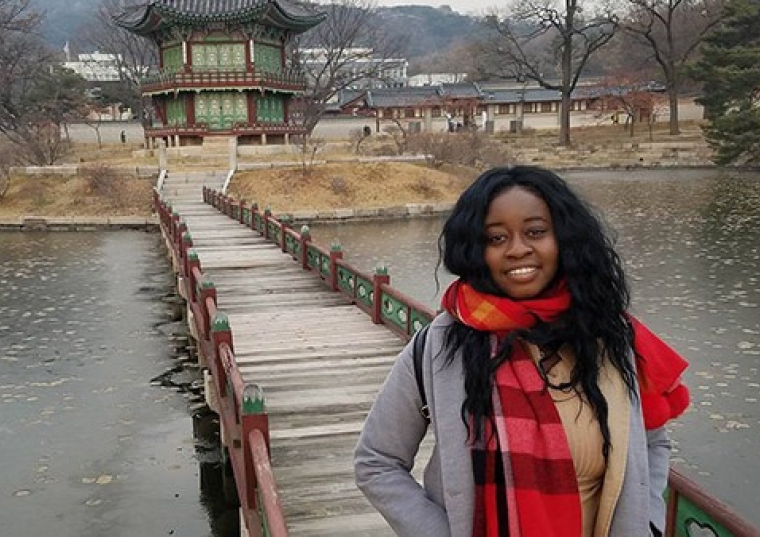 Emmanuella Bonga Bikele in front of a bridge over a river