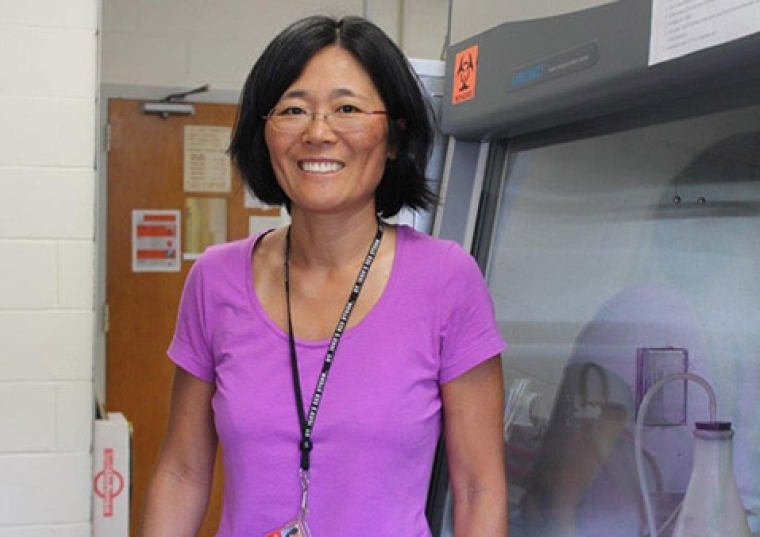 Rachel Zufferey, Ph.D. standing in the lab wearing a purple shirt