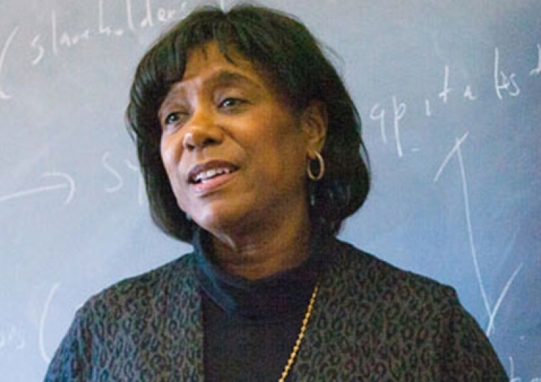 Dr. Joan Tropnas in front of a chalkboard