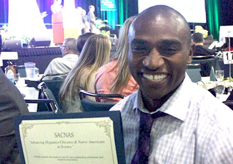 Eric James '11C holding up an award