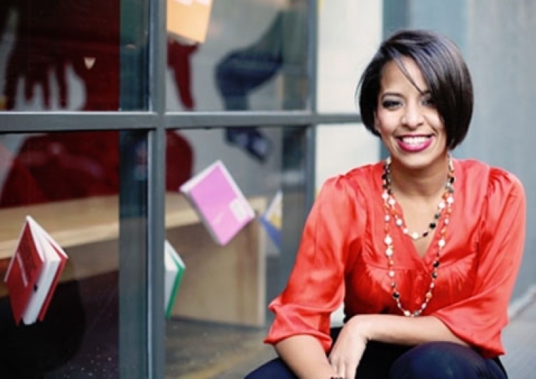 Soribel Genao, Ph.D. ’03CPS outside a window with books hanging up