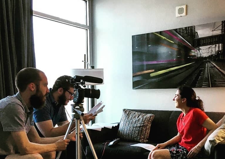 Evan Gardner and Austin filming a young woman on a couch talk for a documentary
