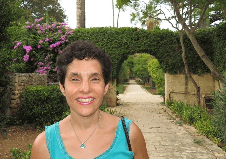 Daniella Bernett with an outdoor garden and path behind her