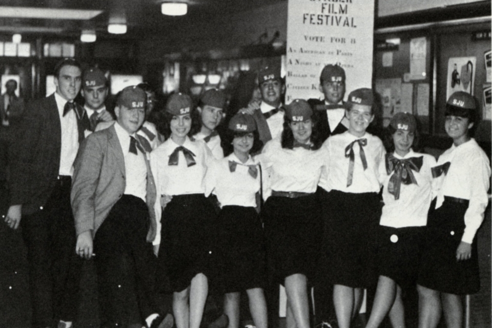 A group of students wearing red beanies and red bowties as part of the required freshman hazing in 1965.
