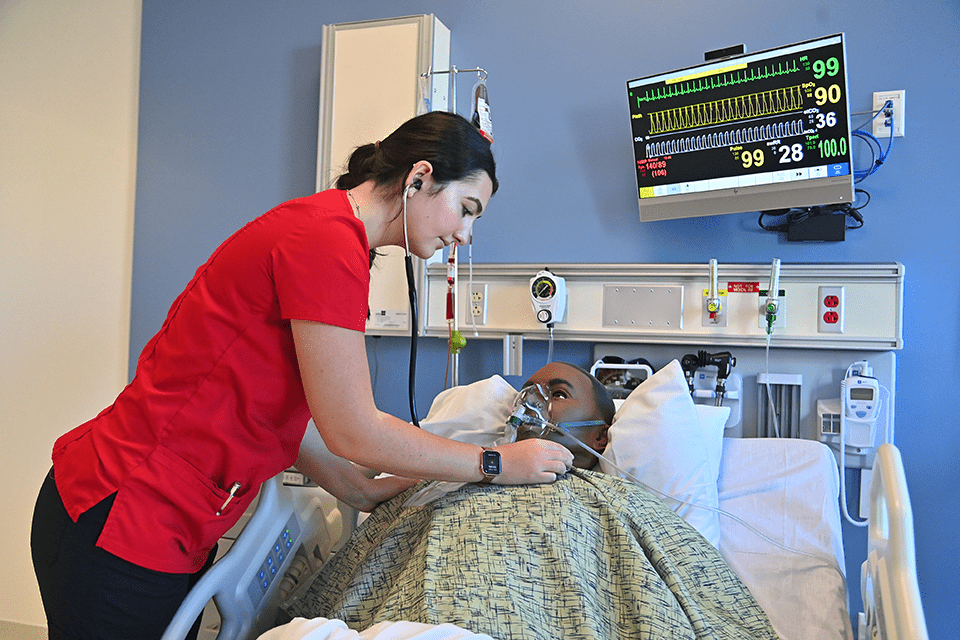 Student nursing practicing on mock patient