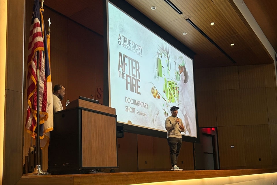 Man speaking in front of a presentation screen
