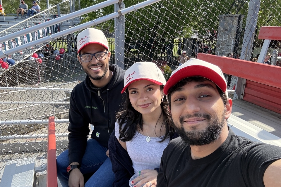 Three college students attending a baseball game