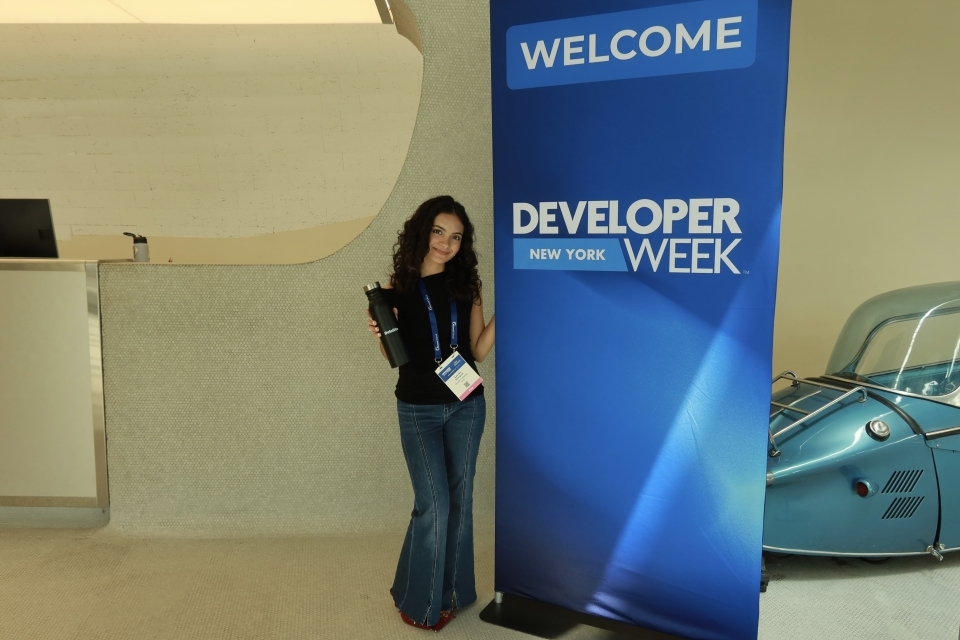 Young student standing in front of Develop Week sign
