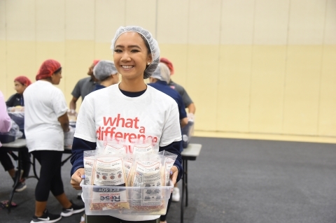 St. John's student volunteering, holding bin of supplies