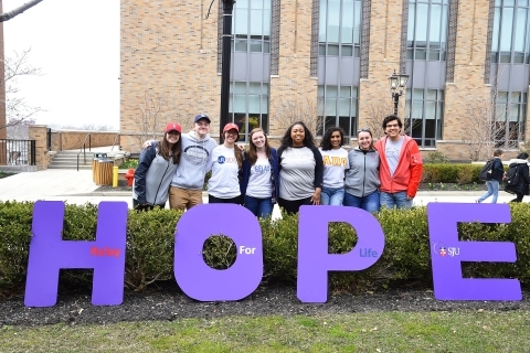 Students standing with purple letters HOPE