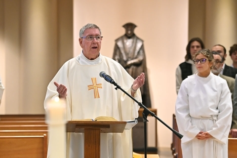 Rev. Richard Rock at podium in St. Thomas More Church during Mass