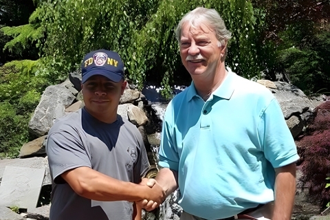 Eugene J. Carty ’73GEd. shakes the hand of Sgt. Gabriel Vazquez ’18CPS