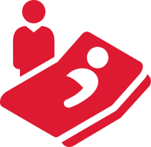 One graphic person standing next to a bed with a person in bed sick