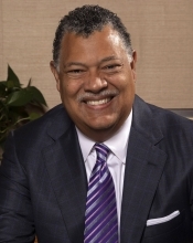 Man facing camera sitting at desk