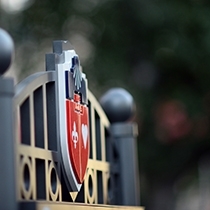 St. John's University crest on the top of the gate