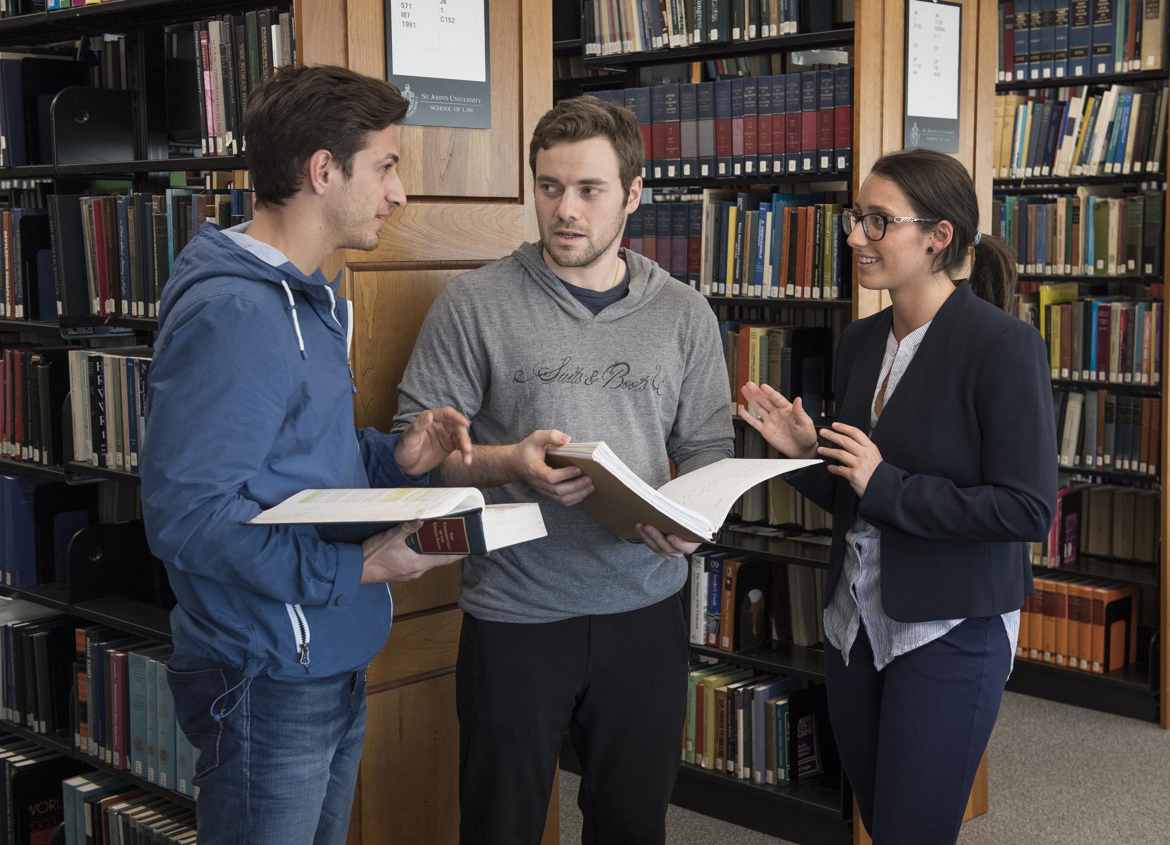 Three law students conversing in the library