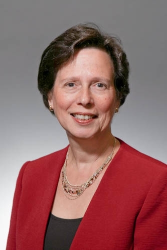 Professor Beizer's professional head shot, wearing a red blazer and black top