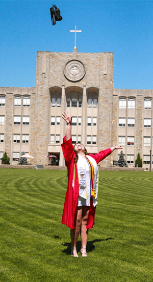 Alicia Venter tossing her grad cap in the air on the Great Lawn